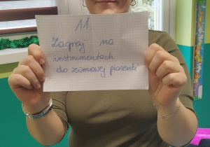 opiekunka pokazuje kartkę z napisanym zadaniem