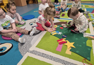 dziewczynki przyczepiają ozdoby, a reszta dzieci patrzy