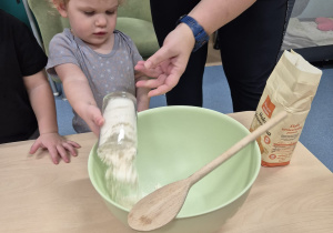 dziewczynka wsypuje mąkę do miski