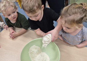 chłopiec wsypuje mąkę do miski