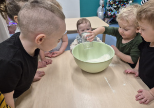 chłopiec wsypuje mąką do miski