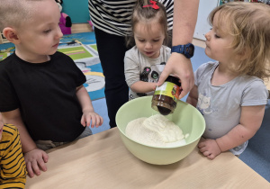 dziewczynka wlewa masę czekoladową do miski