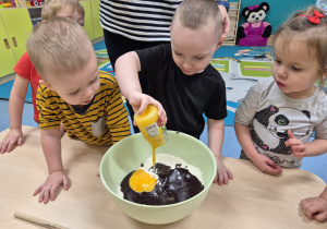 chłopiec wlewa żółtka do miski