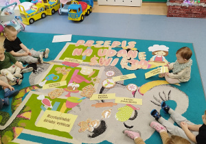 dzieci siedzą na dywanie a przed nimi ułożony już przepis