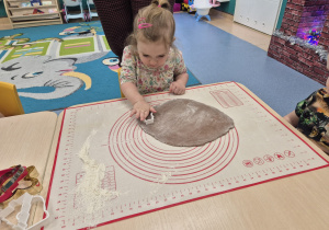 dziewczynka wykrawa foremką piernika