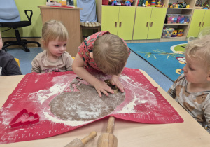 chłopiec wykrawa z ciasta piernika a dzieci patrzą