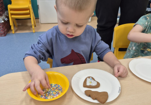 chłopiec bierze posypkę w paluszki