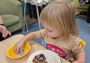 dziewczynka bierze posypkę z miseczki