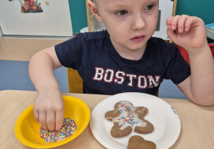 chłopiec bierze posypkę w paluszki