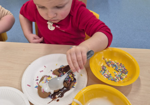 chłopiec smaruje lukrem pierniczka