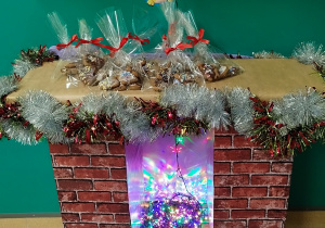 kominek , a na nim leżą popakowane w torebki pierniczki