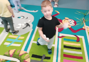 chłopiec trzyma papierową kulkę, zamierza ją rzucić