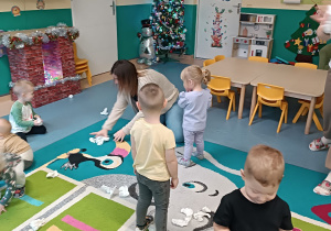 opiekunka i dzieci zbierają kulki na dywanie