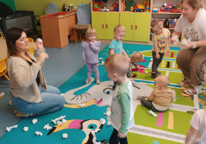 opiekunki i dzieci rzucaja papierowe kulki