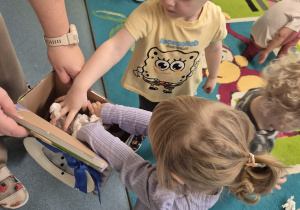 dzieci wrzucają kulki do kartonu z bałwankiem