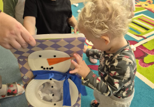 dzieci wrzucają kulki do bałwanka