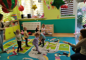 dzieci i opiekunki rzucaja papierowe kulki