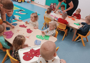 dzieci ozdabiają rękawiczki, opiekunki pomagają dzieciom