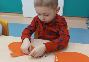 chłopiec przykleja ozdoby do rękawiczki