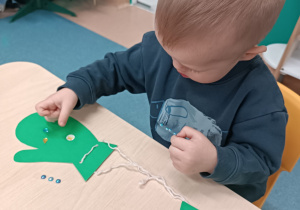 chłopiec przykleja naklejki do rękawiczki