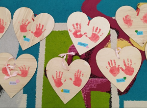 Drewniane serca z odbitymi rączkami dzieci