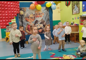 dzieci pokazują i tańczą do piosenki