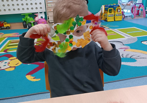 chłopiec pokazuje jaką piękną maskę zrobił