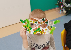 chłopiec spogląda przez zrobioną maską