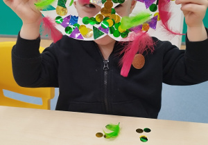 chłopiec pokazuje maskę, którą udekorował