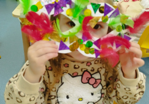 dziewczynka pokazuje maskę, którą zrobiła