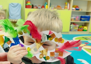 chłopiec patrzy przez zrobioną przez siebie maskę