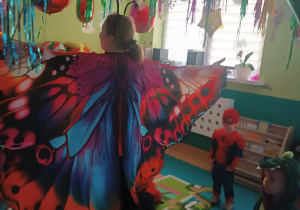 opiekunka stoi i rozkłada założone skrzydła