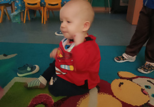 chłopiec siedzi na dywanie