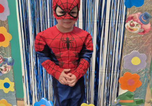 chłopiec przebrany za spidermana z maską na twarzy pozuje w fotobudce