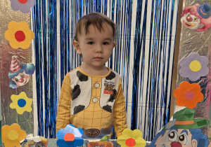 chłopiec pozuje do zdjęcia w fotobudce