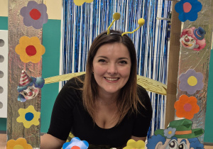 opiekunka pozuje do zdjęcia w fotobudce, uśmiecha się