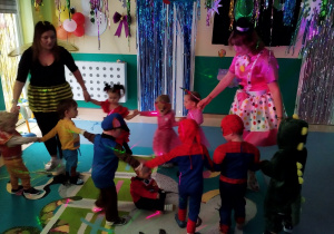 dzieci i opiekunki tańczą robiąc koło