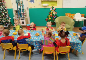 dzieci siedzą i zajadają przekąski