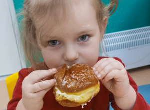 dziewczynka gryzie pączka