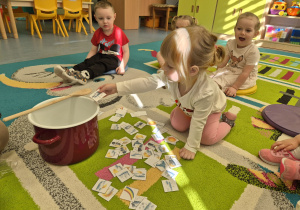 dziewczynka wrzuca do garnka wybrany obrazek