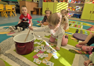 dziewczynka miesza w garnku dużą drewnianą łyżką