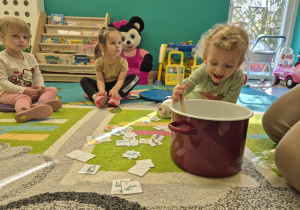 chłopiec miesza drewnianą łyżką w granku i uśmiecha się