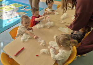 dzieci przyklejają watę do kartonowej chmurki