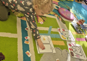 chłopiec układa obrazek w prawidłowe miejsce