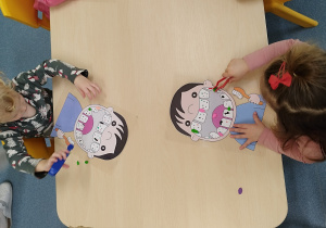 dzieci szczypcami zbierają kulki z plasteliny