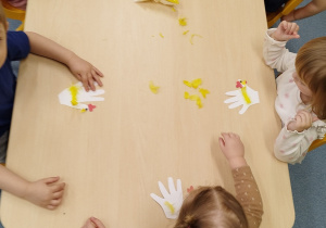 dzieci przyklejaja piórka