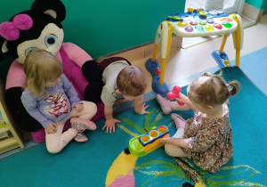 dziewczynka puka młotkiem , a dziewczynka i chłopiec się przygląda