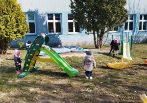 dzieci na podwórku biegają i zjeżdżają ze zjeżdżalni