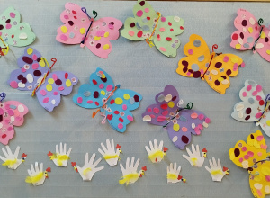 papierowe motyle wyklejone przez dzieci wiszą na tablicy