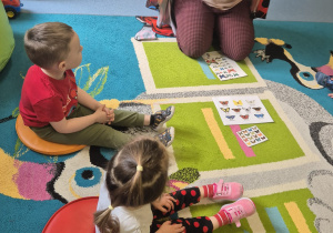 opiekunka opowiada dzieciom skąd się biorą motylki